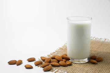 Milk with almonds nut on white background.