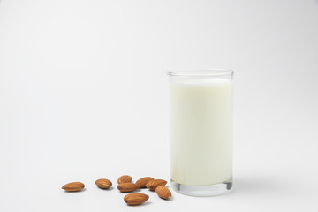 Milk with almonds nut on white background.