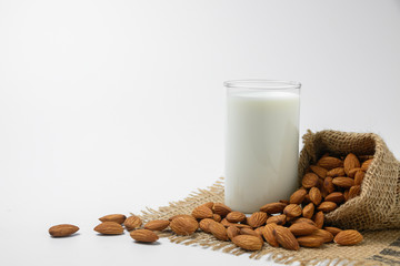Milk with almonds nut on white background.