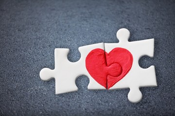 Two pieces of a puzzle with red heart