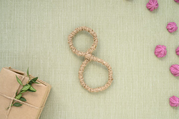Happy Women's Day. Background for Women's Day. Greeting card international women's day March 8. box of Kraft paper, pink marshmallow and the number eight lie on paper background