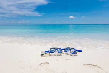 Summer sport, beach activity, beach recreational concept. Diving goggles and snorkel gear on white sand near beach. Summer vacation and recreational travel background - obrazy, fototapety, plakaty