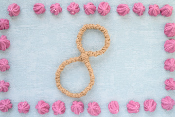 Happy Women's Day. Background for Women's Day. Greeting card international women's day March 8. frame from pink marshmallow and the number eight lie on paper background