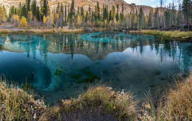 Blue geyser lake in the mountains