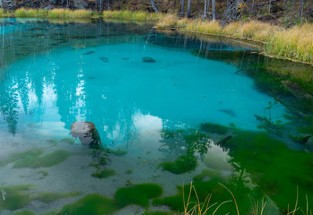 Blue geyser lake in the mountains