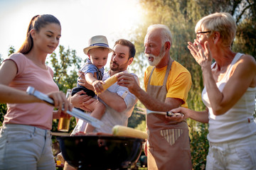 Happy family barbecuing meat on the grill