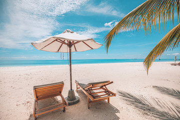 Chairs at the beach with white umbrella. Luxury beach vacation and summer travel landscape. Amazing summer mood, relaxation concept. Exotic nature, tropical pattern