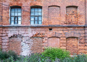 Vintage architecture classical industrial facade old abandoned red brick building front view.