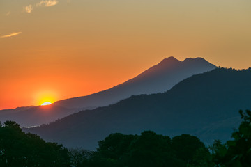 Beautiful and colorful sunrise having the sun coming up at the base of a volcano