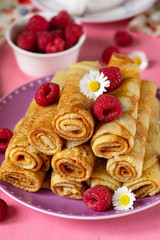 Stack of thin pancakes crepes served with raspberries