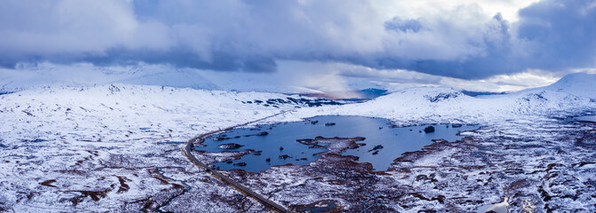 aerial drone shot of rannoch moor and the entrance to glencoe in winter with Lochan na h-Achlaise during march