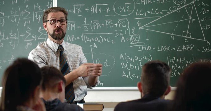 Excited bearded math teacher explaining material to pupils, loving profession