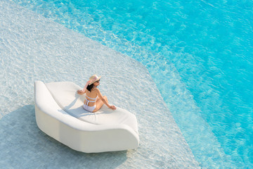 Top view of Asian woman wearing sexy white swimsuits with sunglasses and hat leisure and relaxing...