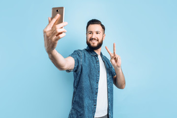 a young man takes a selfie on a smartphone