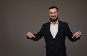 Happy Young Businessman Presenting Isolated Over Grey Background. Copyspace.