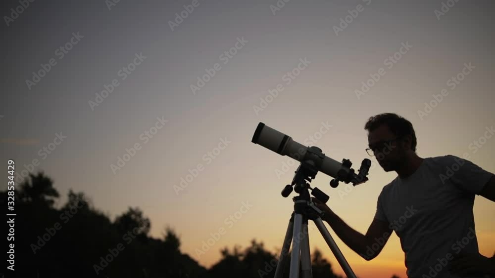 Canvas Prints astronomer with a telescope watching at the stars and moon.