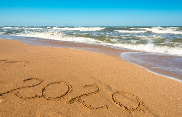 Inscription on sea sand 2020 year on sea shore
