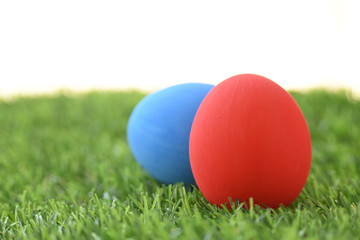 Fototapeta na wymiar blue and red easter egg on lawn green grass artificial with blank white background