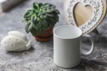 Mockup mug on a gray background with leaves.