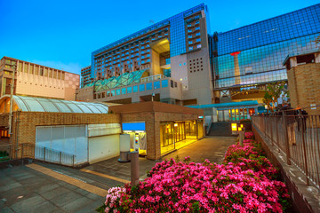 Wide view of Kyoto Tower reflects on glass facade of Kyoto Station building from Karasuma side. Kyoto Station is a major railway station and transportation hub in Kyoto, Japan. Spring season.