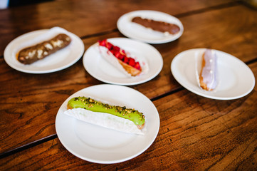 Traditional french Eclairs with original decor on a brown background table.