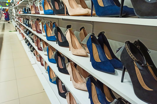 Background with shoes on shelves of shop. Women's shoes on a shelf in the store. Retail sale of shoes.