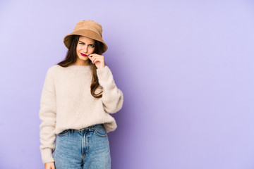 Young caucasian woman isolated on purple background with fingers on lips keeping a secret.