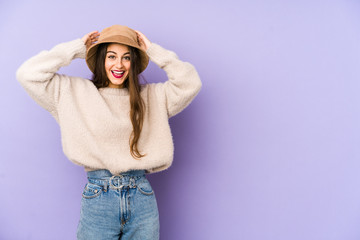 Young caucasian woman isolated on purple background screaming, very excited, passionate, satisfied with something.