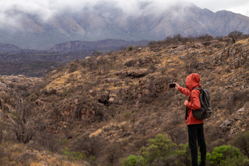 Fototapeta na wymiar young backpacker taking selfie in the mountains with clouds