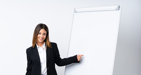 Young woman giving a presentation on white board giving a presentation on white board and pointing it