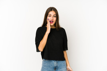 Young caucasian woman isolated on white background shouts loud, keeps eyes opened and hands tense.