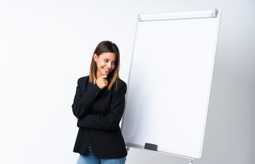 Young woman giving a presentation on white board looking side