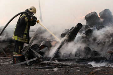 Brave firefighter saving burning building. Firefighter work concept. Firefighter are using water in...