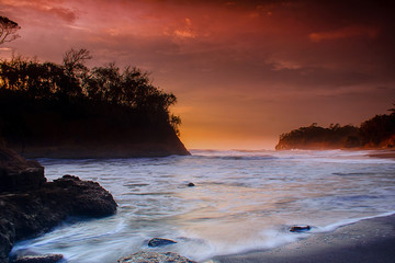 the beauty of the beach in the afternoon with the waves rolling in between the beautiful islands in Indonesia