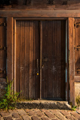 Ancient wooden door of a ruined wooden house in old town.