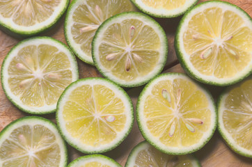 Sliced limes on wooden table, flat lay