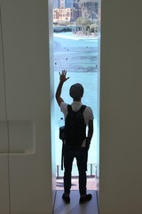 Fototapeta premium Man Standing At Window And Looking At Beautiful Beach View