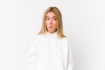 Young blonde caucasian woman isolated shrugs shoulders and open eyes confused.