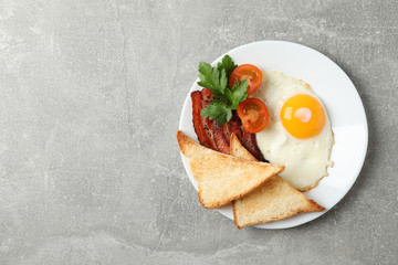 Delicious breakfast or lunch with fried eggs on grey background, top view
