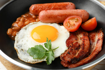 Delicious breakfast or lunch with fried eggs on wooden background, close up