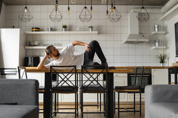 Young freelancer succeeded with project working from home and relaxing laying on the table at the...