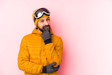 Young skier man isolated relaxed thinking about something looking at a copy space.