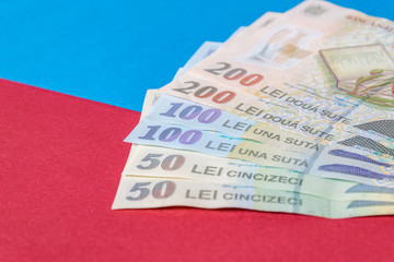 Romanian banknotes on a blue and red background. Coloseup of RON, Romanian Currency. Romanian RON, Lei Banknotes issued by BNR, National Bank of Romania. Romania Finance and economy concept