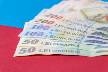 Romanian banknotes on a blue and red background. Coloseup of RON, Romanian Currency. Romanian RON, Lei Banknotes issued by BNR, National Bank of Romania. Romania Finance and economy concept