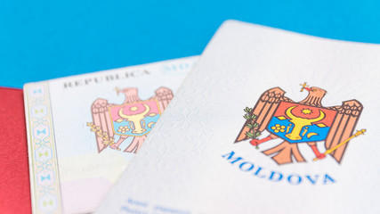 Republic of Moldova concept. The Moldovan passport on a blue and red background. Coloseup of the emblem/coat of arms of Moldova. Moldova Finance and economy concept