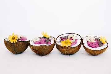 healthy Breakfast berry smoothie with Chia seeds and cashew nuts in a natural coconut plate on a white table