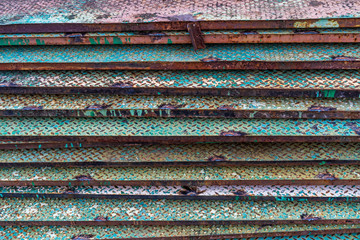 Stair step of old green metal sheet board texture background. Green line paint on non-slip metal background. Rusted diamond steel plate useful as a background. Abstract old multicolor grunge texture.