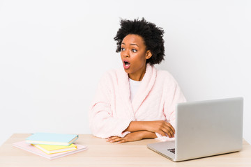 Middle aged african american woman working at home isolated being shocked because of something she has seen.