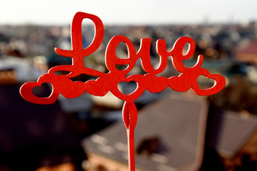 Beautiful, ornate inscription Love. The word love on a wooden stick, against the backdrop of the...