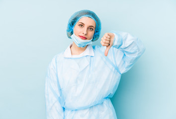 Young surgeon woman isolated showing a dislike gesture, thumbs down. Disagreement concept.
